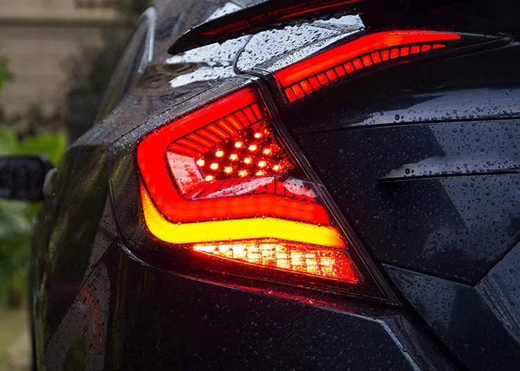 Close-up of a car's taillight with water droplets on a blurred background